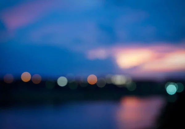 Koyu mavi siyah renk bokeh gökyüzü ve bulut ile gece şehir bulanık ışıklar soyut.