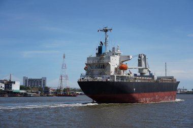 Nehirdeki kargo gemisi açık gökyüzü ile okyanusa doğru