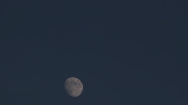 Timelapse de la Lune au bas du cadre avec ciel bleu en arrière-plan 