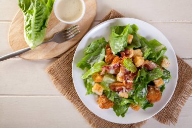 Tavuklu Sezar salata Beyaz ahşap masa arka plan üzerinde