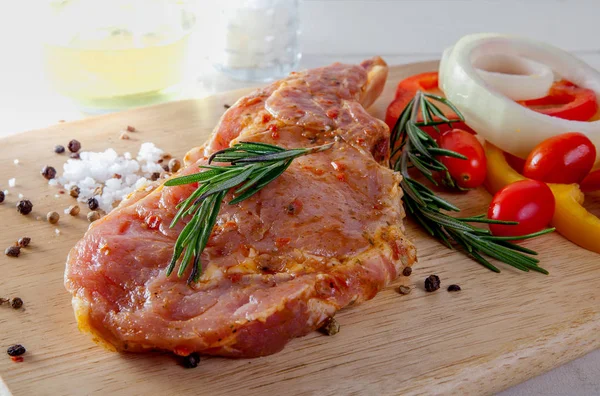 Ahşap arka plan üzerinde çiğ domuz eti biftek.