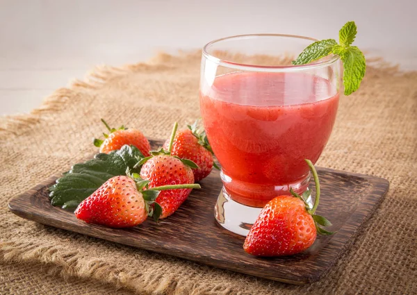 Strawberry cold pressed juice in glass, Healthy raw vegetable and fruit drink for detox.