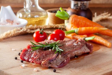 Biftek, sebze ve baharatlı kesim tahtası.