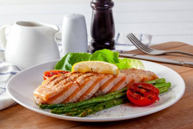 Kızarmış somon bifteği ve taze sebzeli domates..