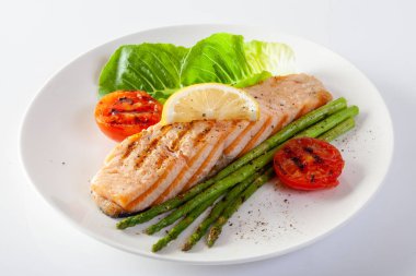 Kızarmış somon bifteği ve taze sebzeli domates..