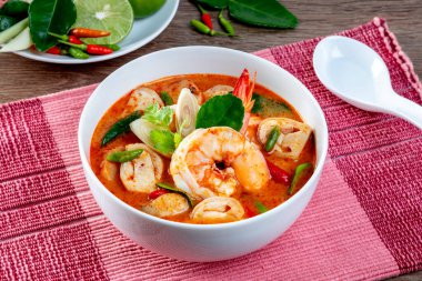 Karides Tom Yum Tahta bir masada beyaz bir kase içinde