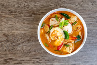 Karides Tom Yum Tahta bir masada beyaz bir kase içinde