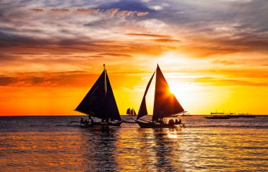 muhteşem tropik günbatımı ve Yelkenli tekneler Boracay, Filipinler silüeti.
