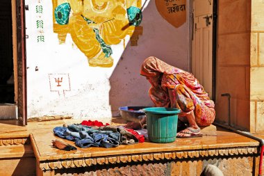 Hindistan gündüz hayatı. Jaisalmer 'in eski caddeleri, çamaşır yıkayan kadınlar. Şubat 2013. Rajasthan, Hindistan