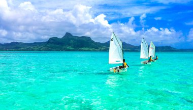 Şeffaf turkuaz deniziyle göz kamaştırıcı Mavi Körfez. Yelkenli çocuklar. Mauritius Adası. Ocak 2020