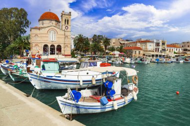 Yunanistan 'ın saronik adaları. Geleneksel balıkçı tekneleri ve Aziz Niklas Kilisesi ile otantik güzel Yunan adası Aegina.
