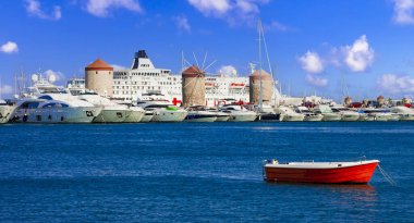 Greece travel, Dodecanese. Rhodes island.  Mandraki Harbor with cruise ships and old windmils clipart