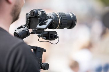 Siyah sabitleyici ile bir tripod ile bir kamera ile video çekim