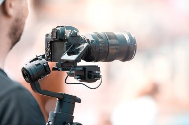Siyah sabitleyici ile bir tripod ile bir kamera ile video çekim