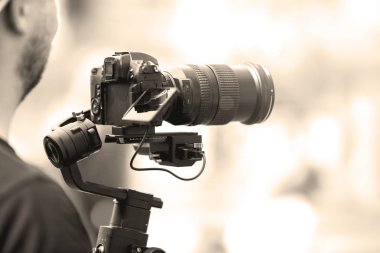 Siyah sabitleyici ile bir tripod ile bir kamera ile video çekim