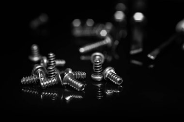 Koyu arka plan üzerinde siyah vidalar