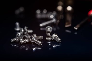 Koyu arka plan üzerinde siyah vidalar