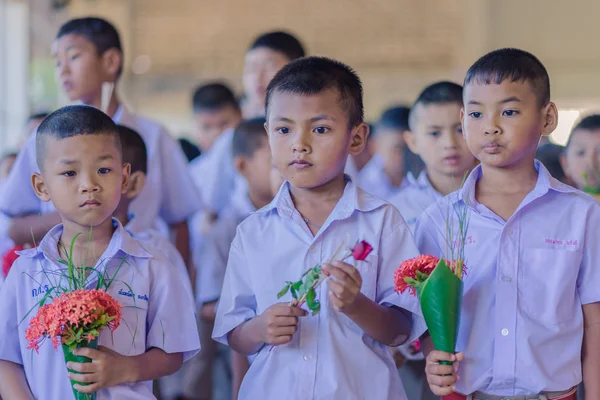 Kanchanaburi Tayland - 14 Haziran: Tanımlanamayan öğrenciler süslemeleri ayaklı tepsi ve Haziran öğretmen günü öğretmenler için vermek için çiçek 14,2018 Kanchanaburi, Tayland için Watkrangthongratburana okulda