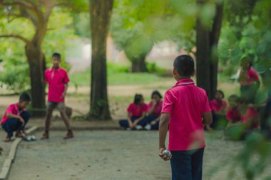 Samimi öğrenciler okulda petank oynarken.