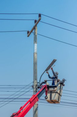 Sokak lambasıyla metal direğin montajı sırasında kaldırma kovasında elektrik akımı.