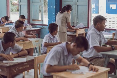 Kanchanaburi Tayland - 16 Temmuz: Tanımlanamayan iyi öğretmen vermek ara sınav soruları öğrencilere sınıfta Temmuz Kanchanaburi, Tayland için Watkrangthongratburana okulda 16,2018