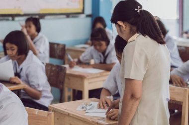 Kanchanaburi Tayland - 16 Temmuz: Tanımlanamayan iyi öğretmen vermek ara sınav soruları öğrencilere sınıfta Temmuz Kanchanaburi, Tayland için Watkrangthongratburana okulda 16,2018