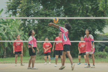 KANCHANABURI THAILAND - 18 Temmuz 2018 'de Kanchanaburi, Tayland' da kimliği belirsiz bayan öğrenciler voleybol oynuyor.