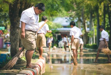 Kanchanaburi Tayland - 8 Ekim: sokaklarda Ekim'de ağır yağmur sonrası temizlemek için Unidentiffied öğrencilere yardım Kanchanaburi, Tayland için Watkrangthongratburana okulda 8,2018