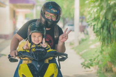 Kanchanaburi Tayland - 10 Ekim: Unidentiffied baba ve onun oğlu yolculuğu bir motosiklet seyahat etmek. Ekim 10,2018 Watkrangthongratburana Okulu Kanchanaburi, Tayland