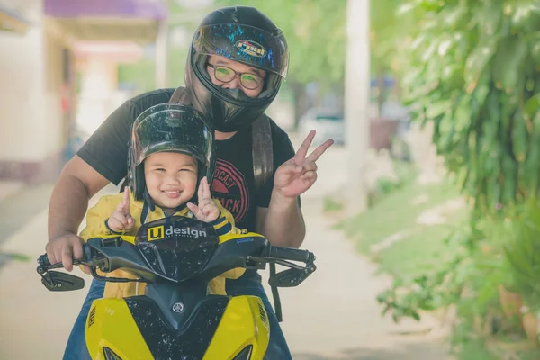 Kanchanaburi Tayland - 10 Ekim: Unidentiffied baba ve onun oğlu yolculuğu bir motosiklet seyahat etmek. Ekim 10,2018 Watkrangthongratburana Okulu Kanchanaburi, Tayland