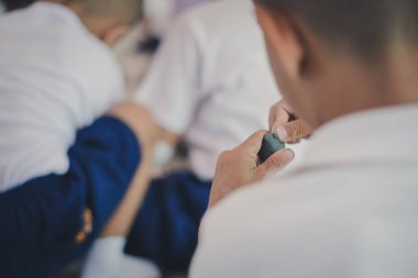 Genç çocuklar okulda hayal güçlerini renkli modelleme kil ile birlikte eğleniyor.