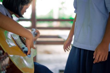 Ortaokul öğrencileri okulda gitar çalmayı öğrenme.