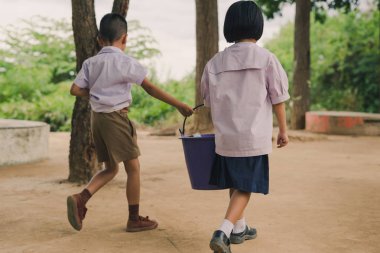 Öğrencilere yardımcı çöp atık yığın için sınıftan kaldırmak için okul.