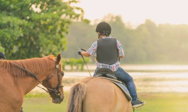 Gün batımından önce Nehri yakınında bir at binmeyi öğrenmek.
