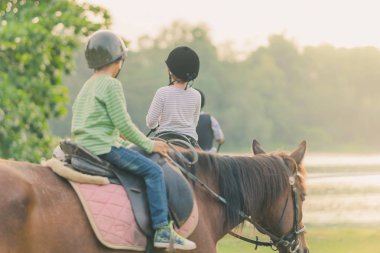 Gün batımından önce Nehri yakınında bir at binmeyi öğrenmek.