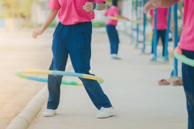 Kız öğrencilerin okulda sağlıklı bir iyiliği için bir çember ile egzersiz yaparak.