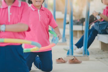 Kız öğrencilerin okulda sağlıklı bir iyiliği için bir çember ile egzersiz yaparak.