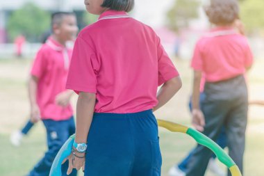 Kız öğrencilerin okulda sağlıklı bir iyiliği için bir çember ile egzersiz yaparak.