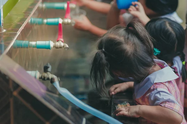 Öğrenciler içme suyu musluk öğle yemeğinden sonra.