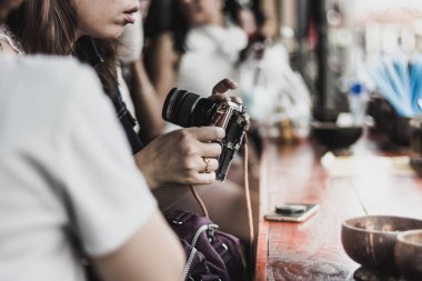 Genç kadın bir kamera Amphawa, Tayland riverside adlı bir fotoğraf çekmeye hazır hale hazırlar