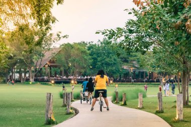 İnsanlar akşam genel parkta Bisiklete binme tarafından egzersiz.