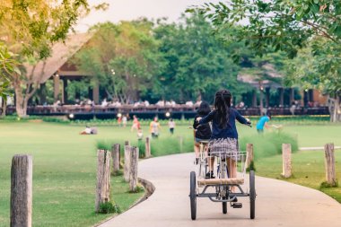 İnsanlar akşam genel parkta Bisiklete binme tarafından egzersiz.