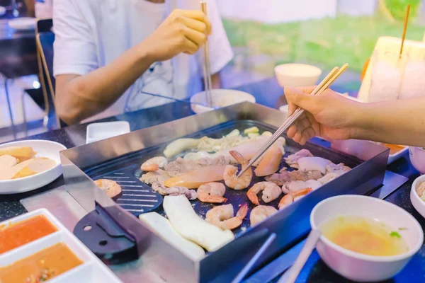 韓国レストランで家族と韓国の Bbq 伝統的な名物を食べる幸せをお楽しみください — ストック写真