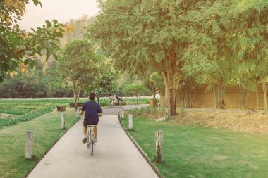 İnsanlar akşam genel parkta Bisiklete binme tarafından egzersiz.