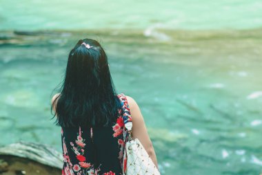 Kadın turist arkadan görünüm dinleniyor ve Erawan şelale Kanchanaburi, Tayland için bir photoghaphy atın