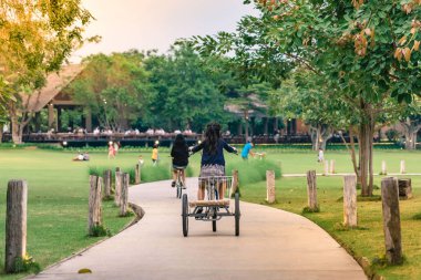 İnsanlar akşam genel parkta Bisiklete binme tarafından egzersiz.