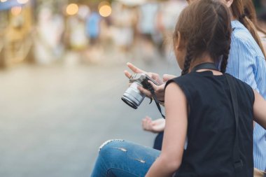 Anne kızı fotoğraf çekmek için öğretir.