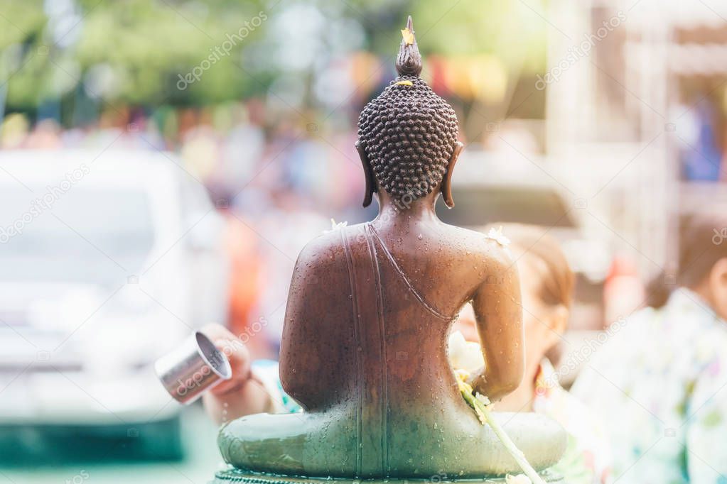 People Shower the monk sculpture in Songkran festival.