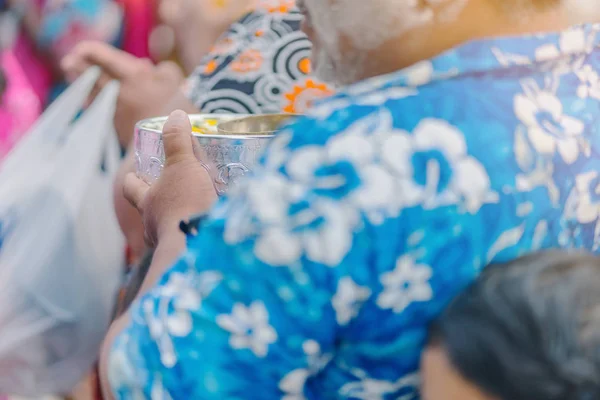 La gente sostiene un cuenco de perfume de agua con flores preparándose para ducharse para los monjes. — Foto de Stock