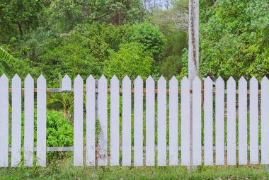 Yol kenarındaki alanda kırık bir tahta ile eski Beyaz ahşap çit